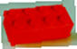 Czerwony płaski klocek plastikowy typu Lego z ośmioma wypustkami na szarym prostokątnym tle