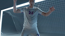 Sportowiec z podniesionymi rękami i numerem 23 na koszulce na tle bramki do piłki nożnej z tyłu szare tło